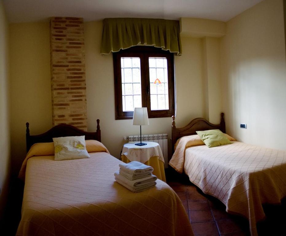阿尔卡拉斯坎瑟塔乡村民宿的一间卧室设有两张床和窗户。