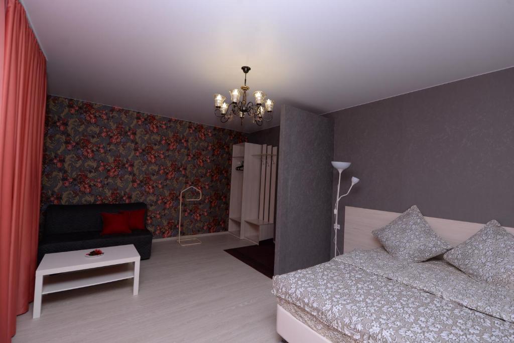 沃洛格达Guest house Sosedi的一间卧室配有一张床和一个吊灯