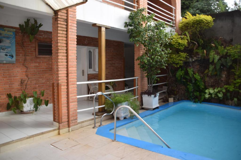 亚松森帕尔马斯德索尔酒店的花园内的游泳池,带房子
