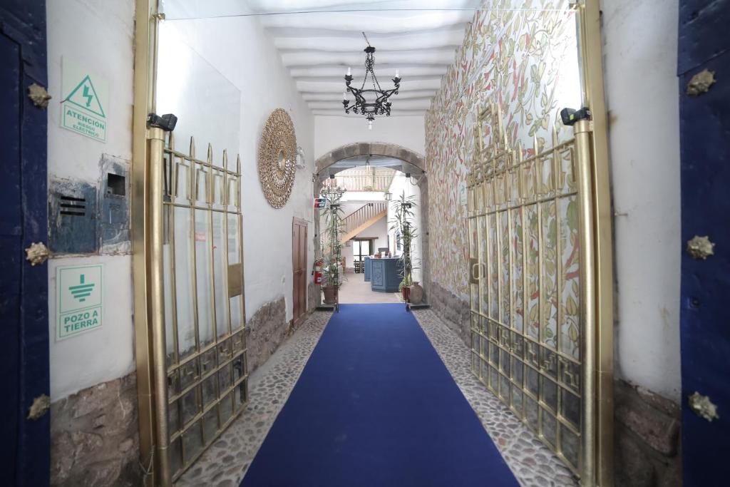 库斯科Posada Villa Mayor的带有门的建筑里带蓝色地毯的走廊