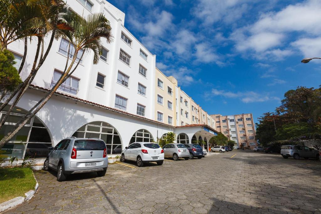 弗洛里亚诺波利斯Tri Hotel Florianópolis的停在大楼前的一组汽车