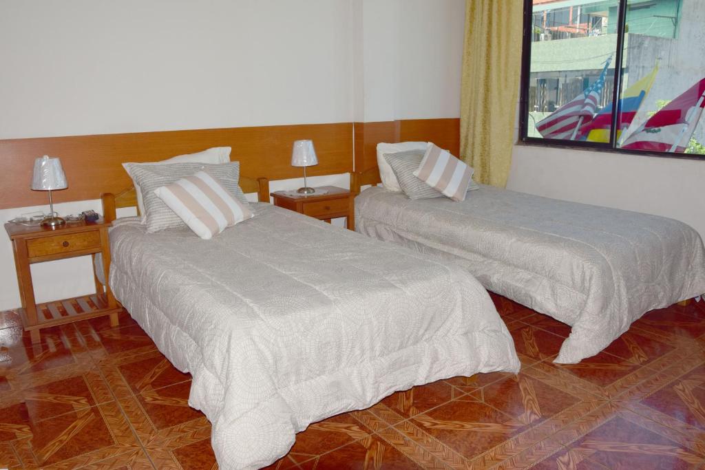 普卡尔帕Casa del Huesped - Guest House的一间设有两张床和两张台灯的桌子的房间