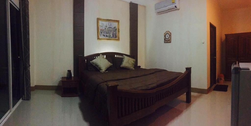Ban Nong Nok Khian塔拉林度假酒店的一间卧室,卧室内配有一张木床
