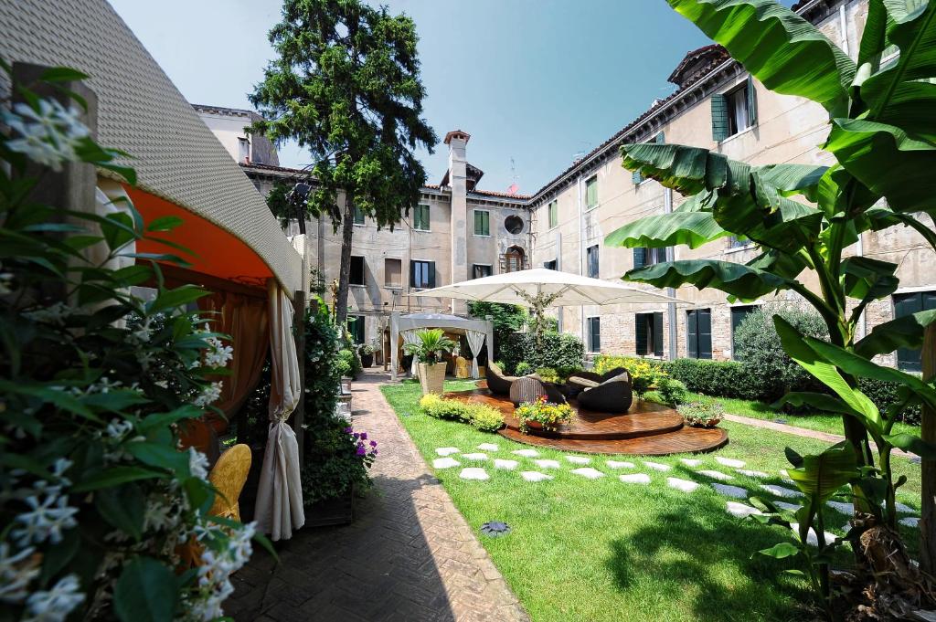 威尼斯阿巴泽亚酒店的庭院内一个带沙发和桌子的花园