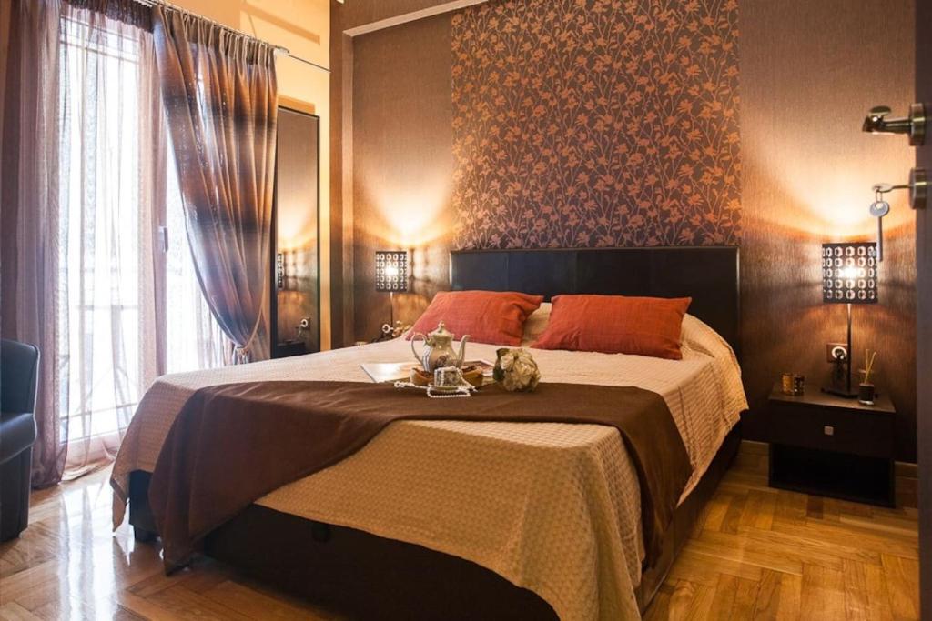 雅典Elegant and Safe Gold and Blue Apartment walk to Acropolis的一间卧室配有一张带橙色枕头的大床