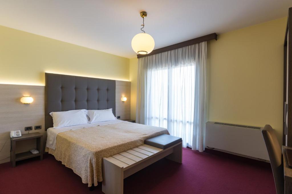 伊特拉那白色公园餐厅酒店的一间卧室设有一张大床和一个大窗户