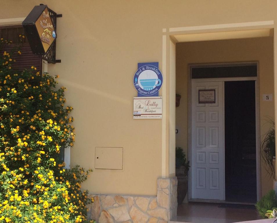 Paravati棒棒糖住宿加早餐旅馆的黄色花卉和标志的房子的前门