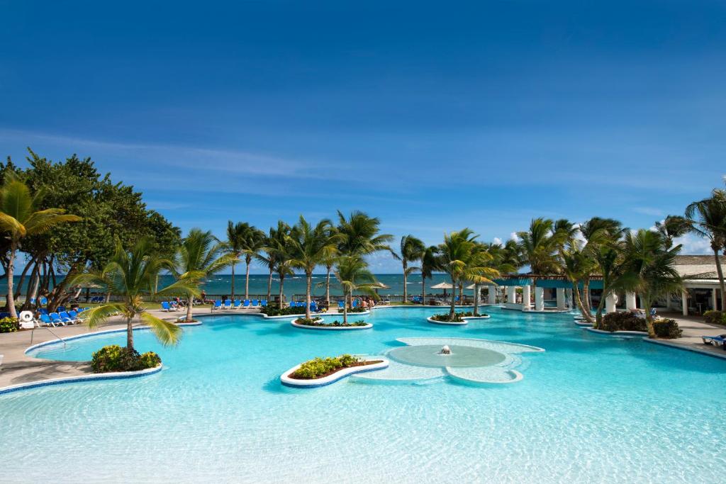 维约堡Coconut Bay Beach Resort & Spa All Inclusive的一个带棕榈树大型游泳池的度假酒店