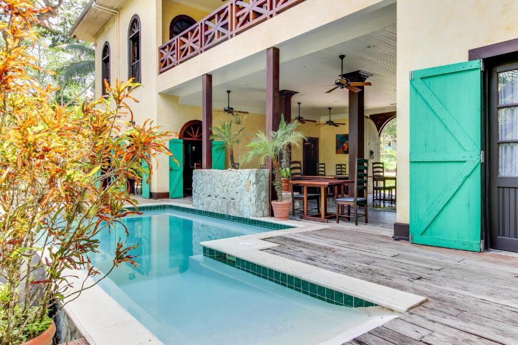 圣伊格纳西奥Colonial Suite @ Mahogany Hall的一座带游泳池和庭院的房子
