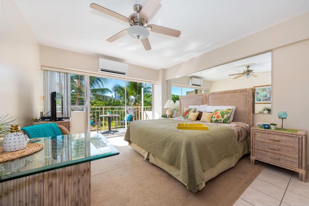 檀香山威基基海岸305号（海滨/阳台）公寓的一间卧室配有一张床和一张玻璃桌