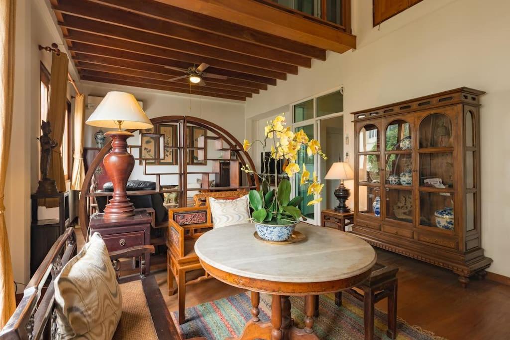 曼谷工匠的古董屋 - 席隆的客厅配有桌子和一些椅子