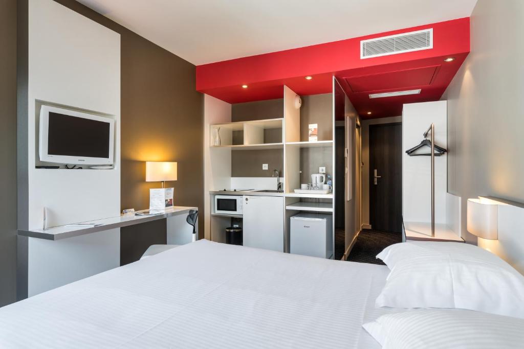 里昂奥特里亚商务与休闲公寓式酒店的卧室配有白色的床和红色天花板