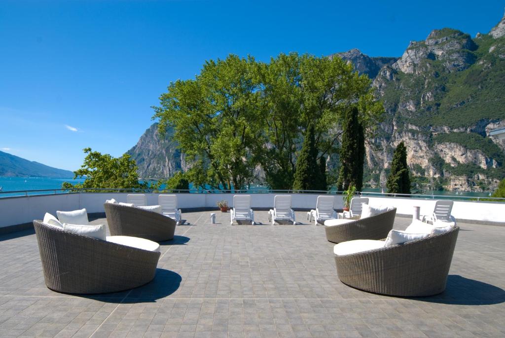 加尔达湖滨奥赛Spa酒店的庭院里摆放着几把椅子和桌子