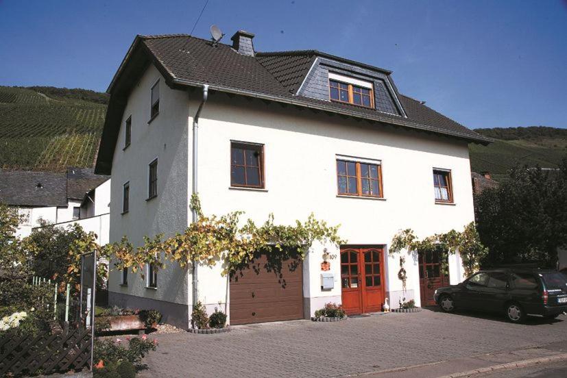 KlüsserathWeingut Berweiler的一间白色的房子,有红色的门和一辆汽车