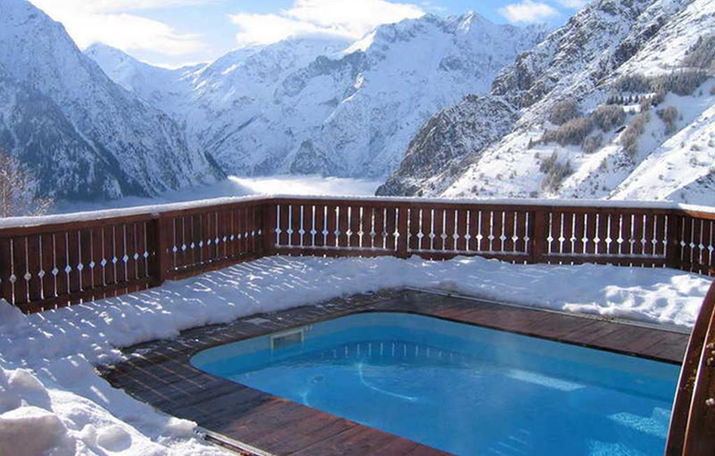 莱德萨阿尔卑斯Odalys Chalet Le Ponton的雪地游泳池,享有山景