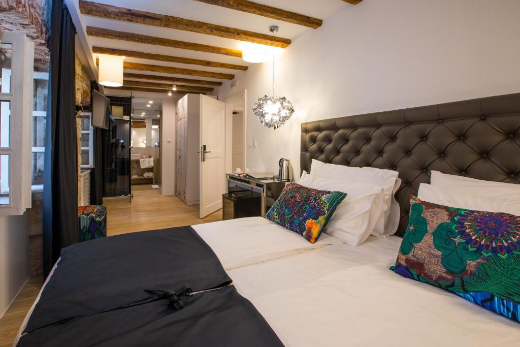 斯普利特斯帕拉多奢华客房住宿加早餐旅馆的一间卧室配有一张大床和黑色床头板