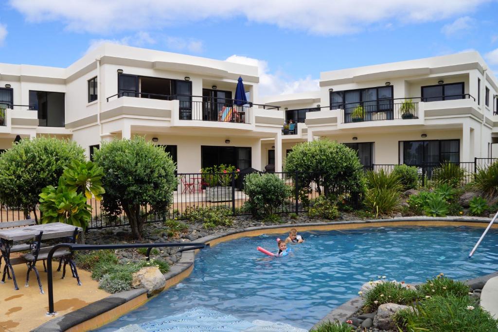 帕瓦努伊帕瓦努伊海风度假公寓的家庭在房子前的游泳池游泳