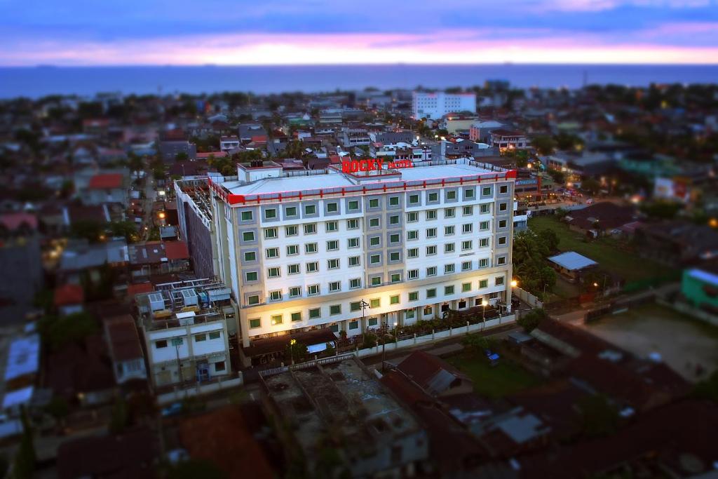 巴东巴东洛基广场酒店的上面有红色标志的白色建筑