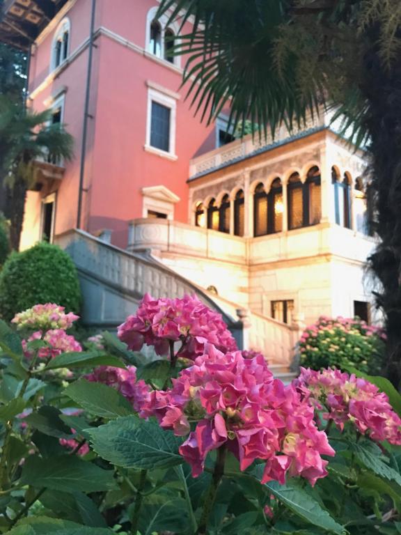 加尔多内-里维耶拉Hotel Villa Fiordaliso的前面有粉红色花的建筑