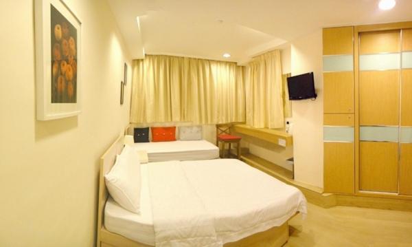 香港 铜锣湾宾馆（波斯富街）的一间卧室配有两张床和电视。