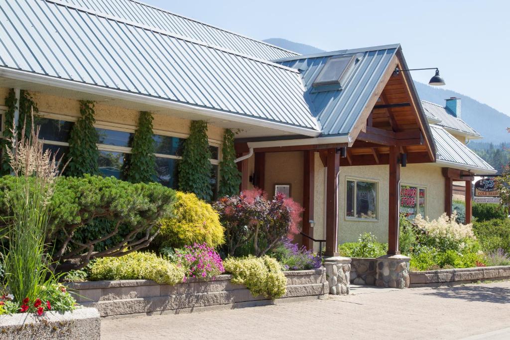 纳卡斯普The Lodge at Arrow Lakes的一座有金属屋顶和一些花卉的房子