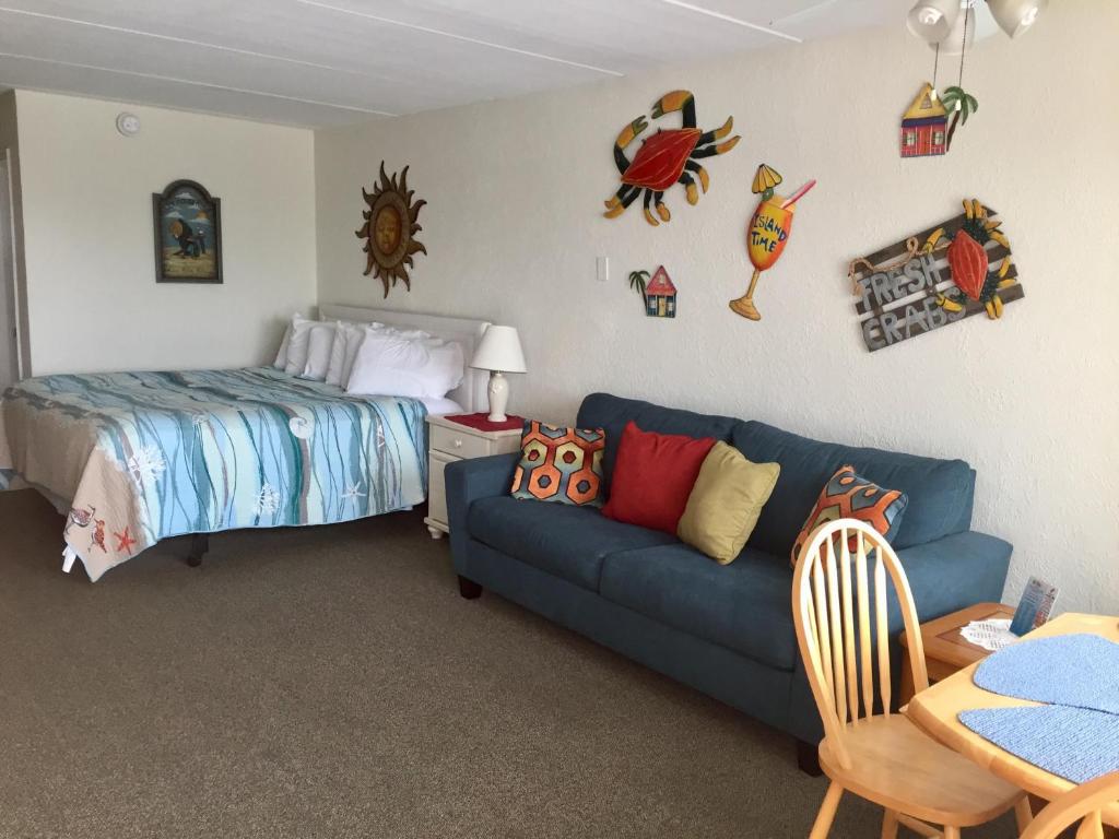 北怀尔德伍德棒棒糖汽车旅馆的一间卧室配有蓝色的沙发和一张床