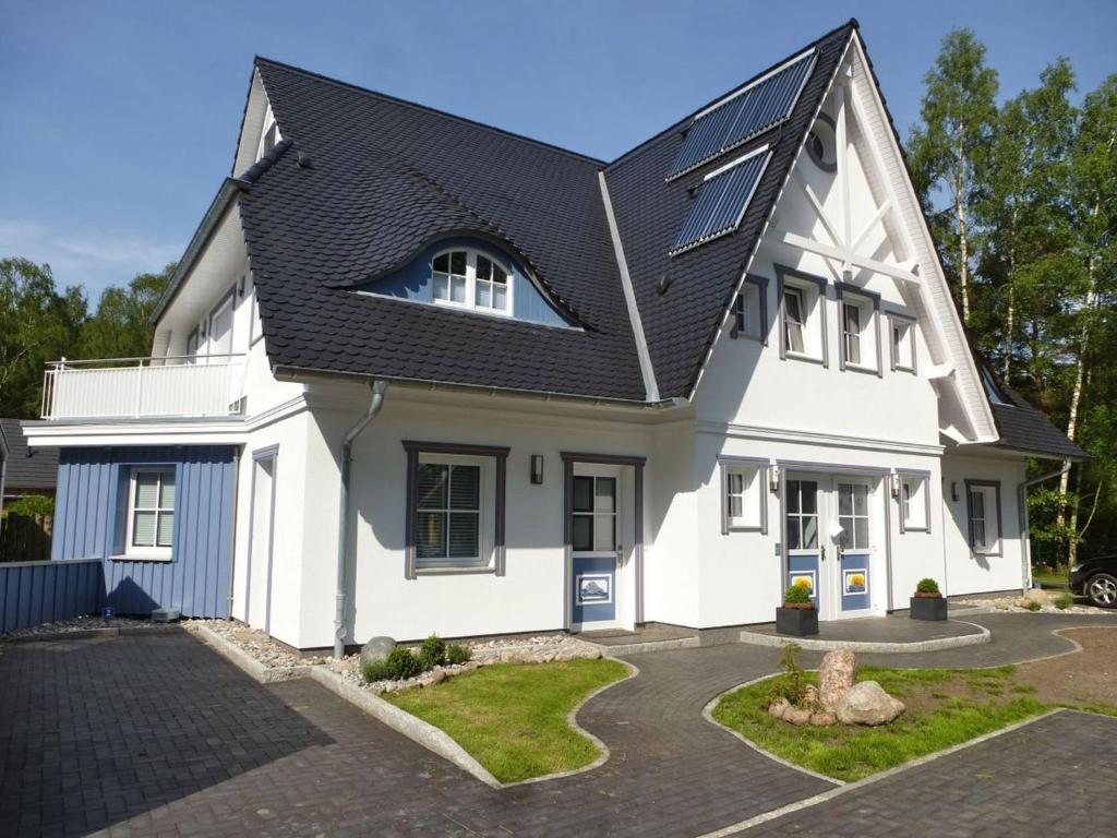 青斯特Lavendelblume - 4 Sterne inklusive Power WLAN - Wäschepaket - BikeBox - Parkplatz # Bestpreisgarantie #的黑色屋顶的白色房子