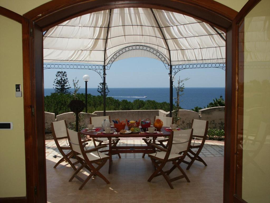 锡拉库扎特拉扎苏尔普勒密里奥酒店的餐桌和椅子,享有海景