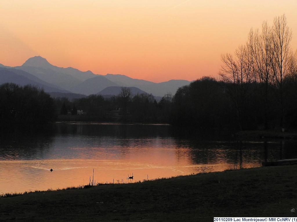 蒙特雷若Les Chalets Montréjeau的山 ⁇ 的湖面日落