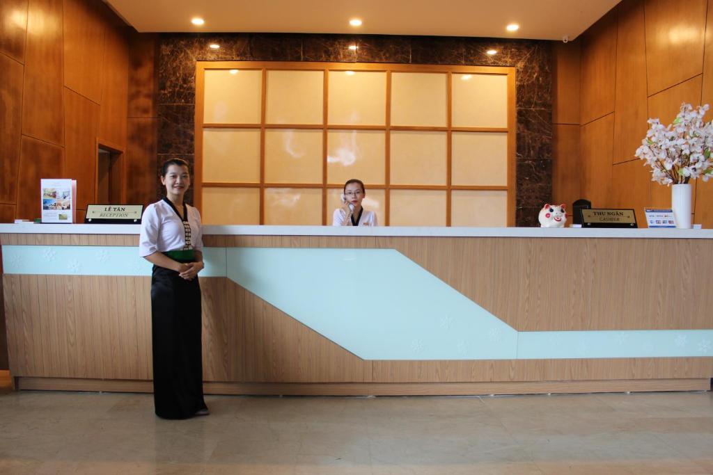 荣市Muong Thanh Cua Dong Hotel的站在接待台前的妇女