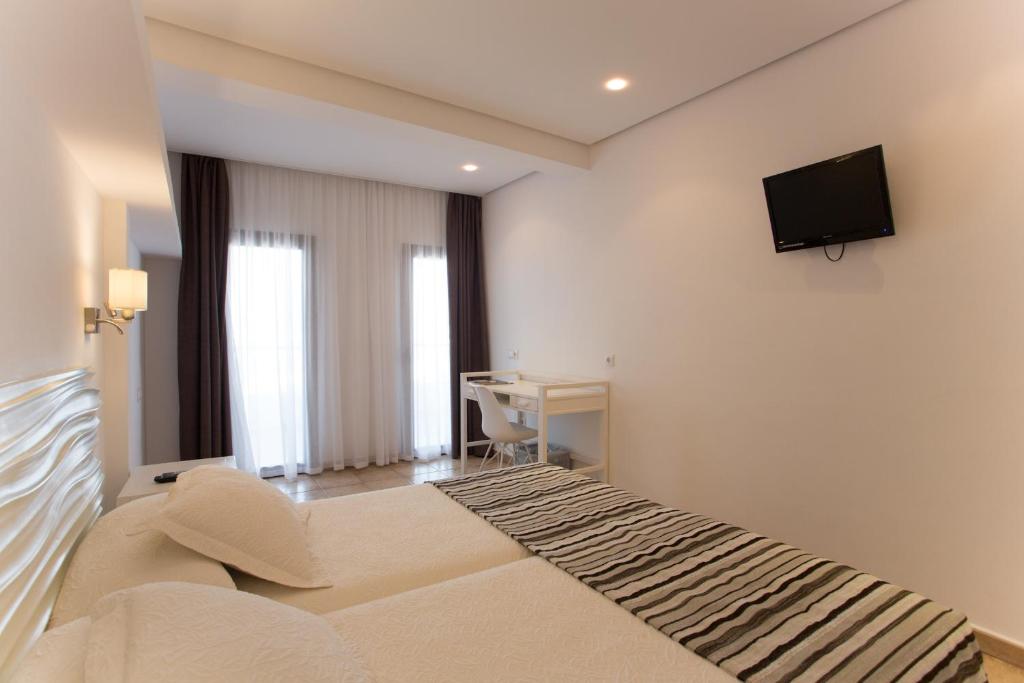 拉萨维纳巴伊亚酒店的卧室配有一张床和壁挂式平面电视。