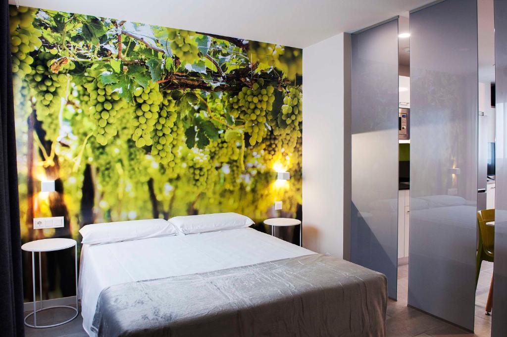维多利亚-加斯特伊兹Apartamentos Divan的卧室配有一张床,并画有葡萄