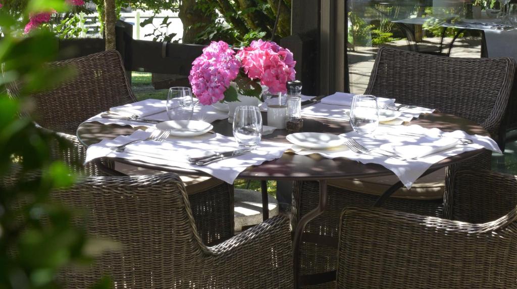 圣瑞尼安国际之家勒瑞莱斯拉吉思酒店的桌子上放着眼镜和花瓶