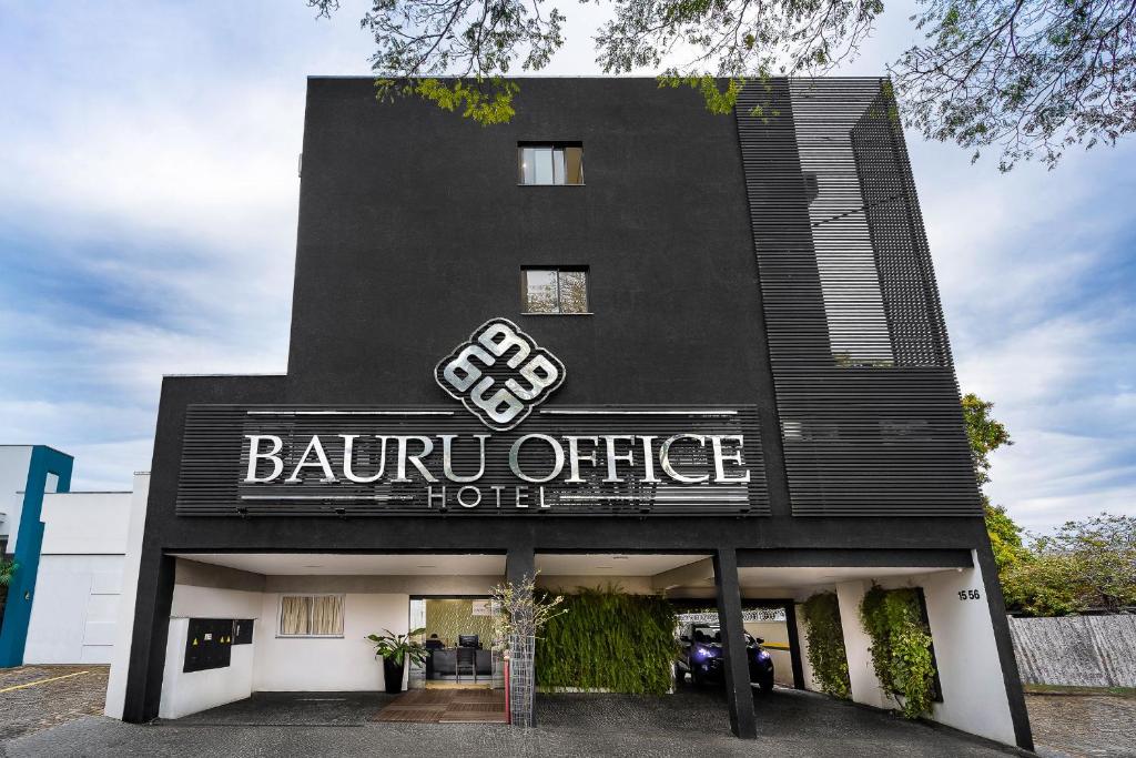 巴乌鲁Bauru Office Hotel的一座黑色的建筑,上面标有酒店标志