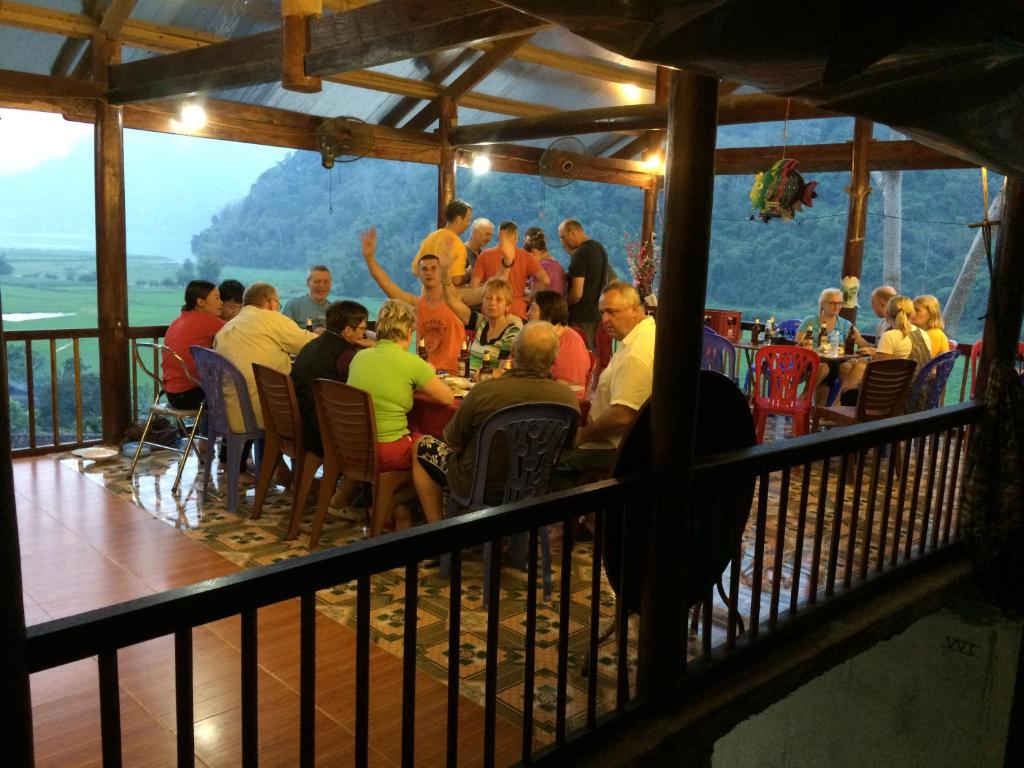 Ba Be18Hoàng Nguyên Homestay Ba Be的一群坐在餐厅桌子上的人