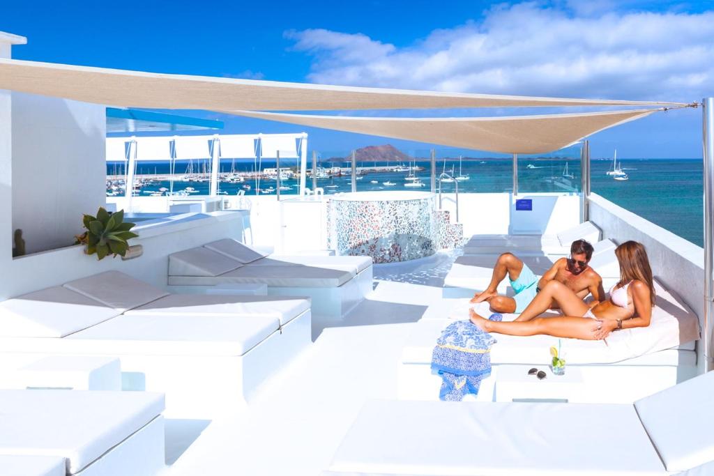 科拉雷侯AVANTI Lifestyle Hotel - Only Adults的两个女人坐在游艇的甲板上