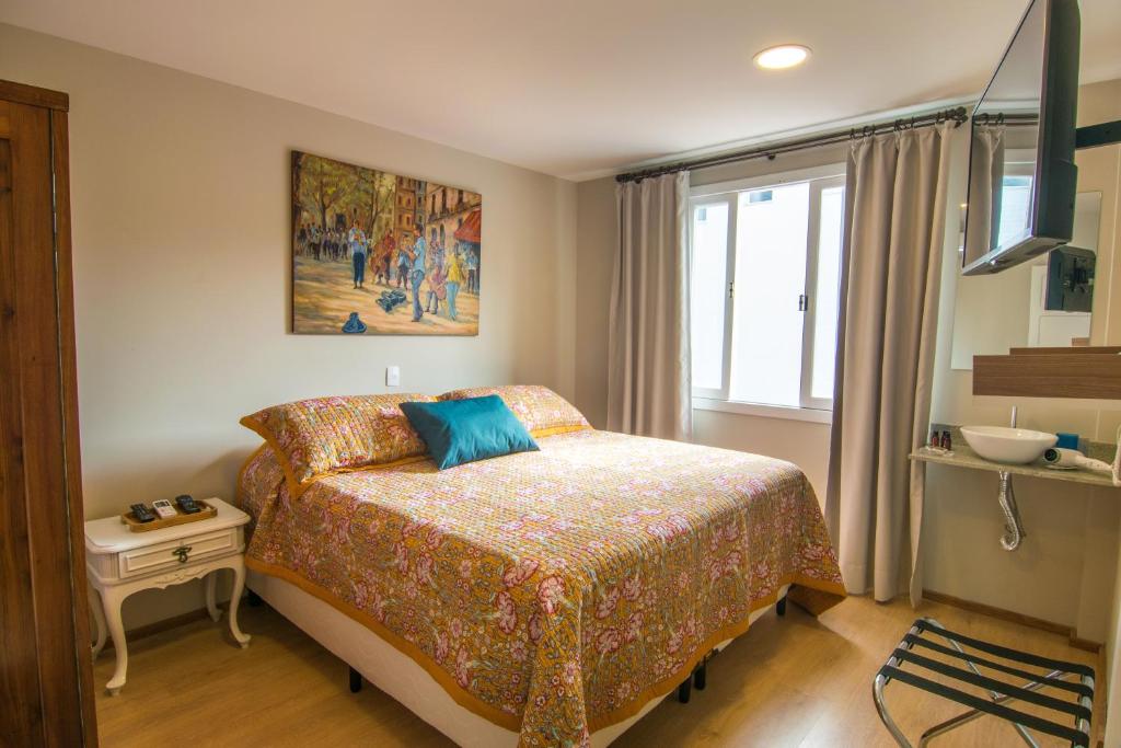 弗洛里亚诺波利斯Hospedaria Conceitual的卧室配有一张床,墙上挂有绘画作品