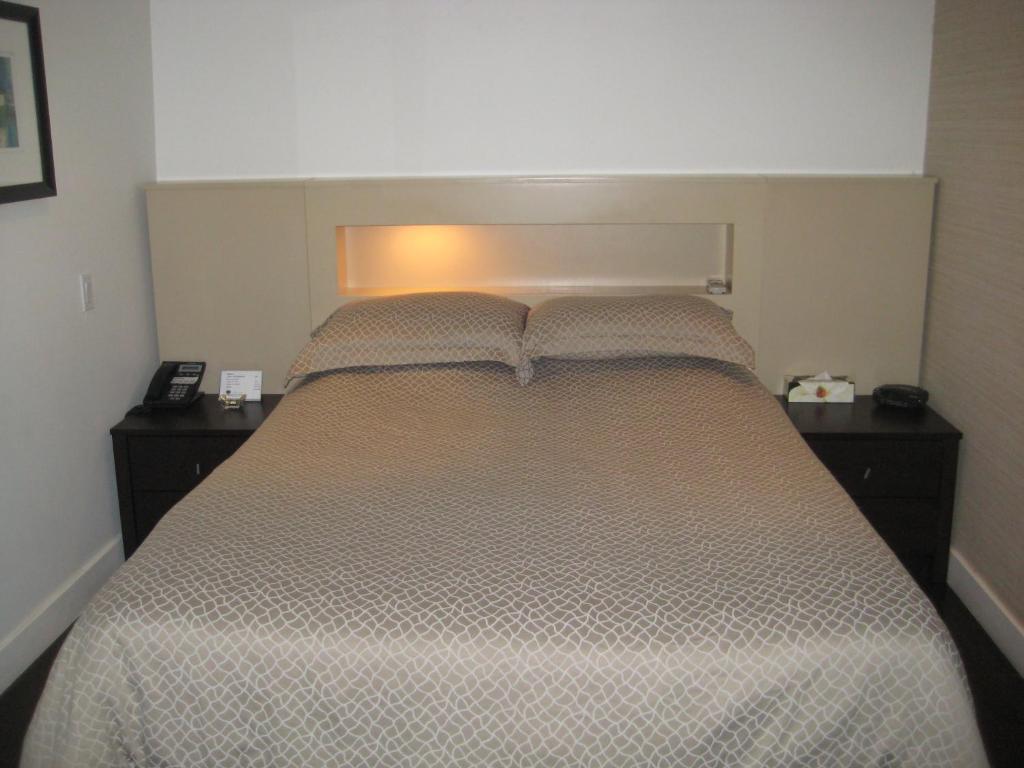 蒙特利尔乐瑞丽里昂酒店的一间卧室配有一张带2个床头柜的大床