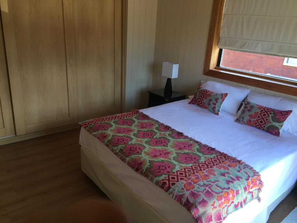 圣马丁德洛斯La Cascada Duplex的一间卧室配有一张带花毯的大床