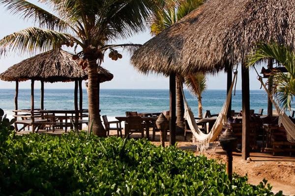 兹波利特炼金术士瑜伽Spa酒店的海滩上设有椅子和遮阳伞,还有大海