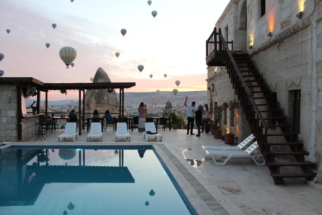 格雷梅舒斯特灵洞酒店的一组热气球在游泳池上空飞行