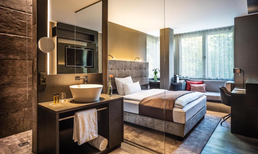 美因河畔法兰克福法兰克福萨克斯城市设计酒店的一间卧室配有床、水槽和镜子