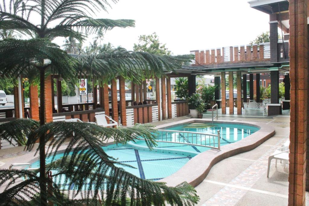 珍南海滩兰卡威我的别墅酒店的一座棕榈树游泳池和一座建筑