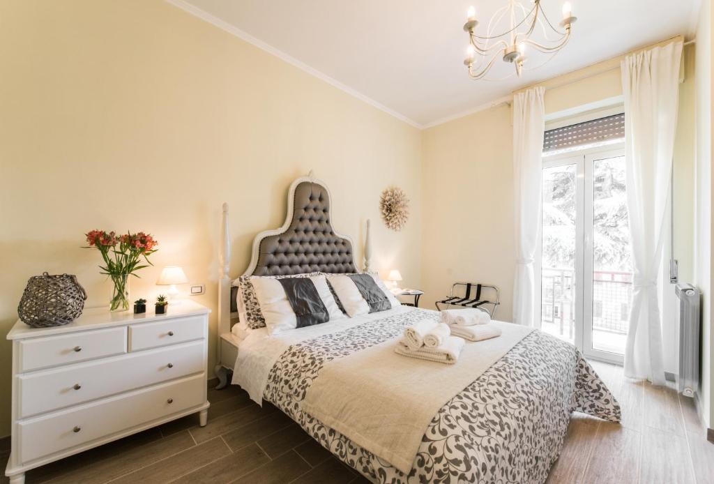 蒂沃利Tivoli Charming Houses - Domus Aefula and Domus Albula的一间卧室配有一张床、一个梳妆台和一扇窗户。