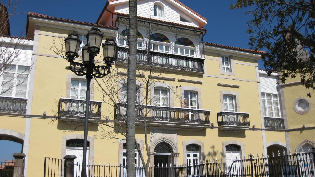 Garaña帕拉西奥加拉纳酒店的带阳台的黄色建筑和街灯