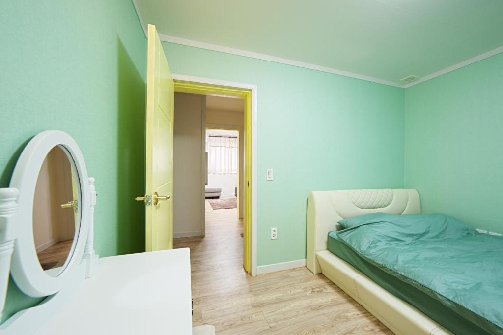 南海郡Namhae Frankfurt Pension的一间卧室配有一张床和镜子