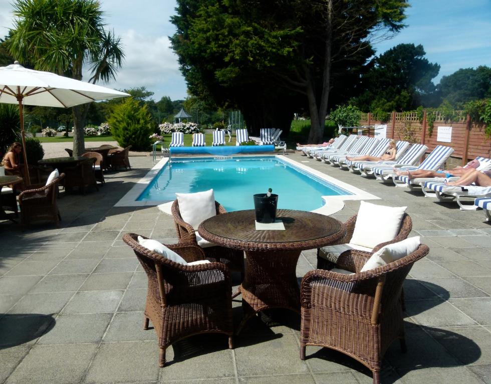 圣赫利尔泽西海浪酒店的游泳池旁的桌椅