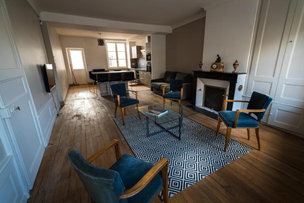 米尔库尔Les Gites Historiques的客厅配有蓝色椅子和壁炉