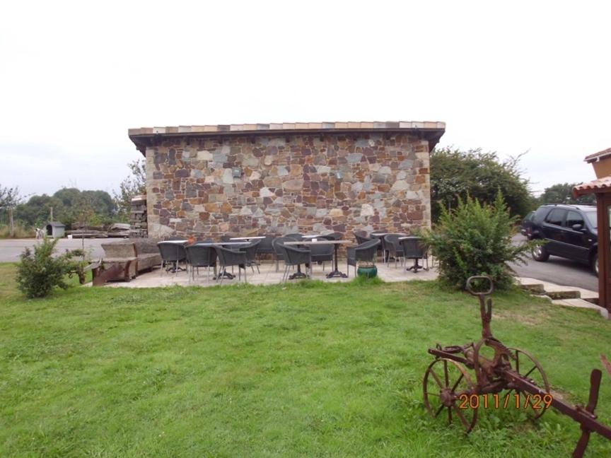 CarrenoCasona Los Gamonales的一座石头建筑,在院子里设有桌椅