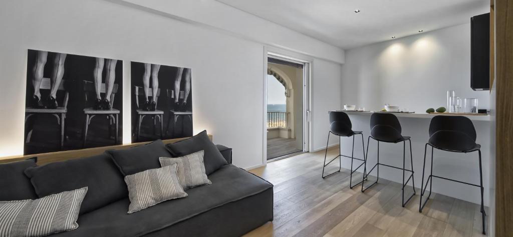 里乔内Luxury Suites Collection - Frontemare Viale Milano 33的带沙发的客厅和厨房